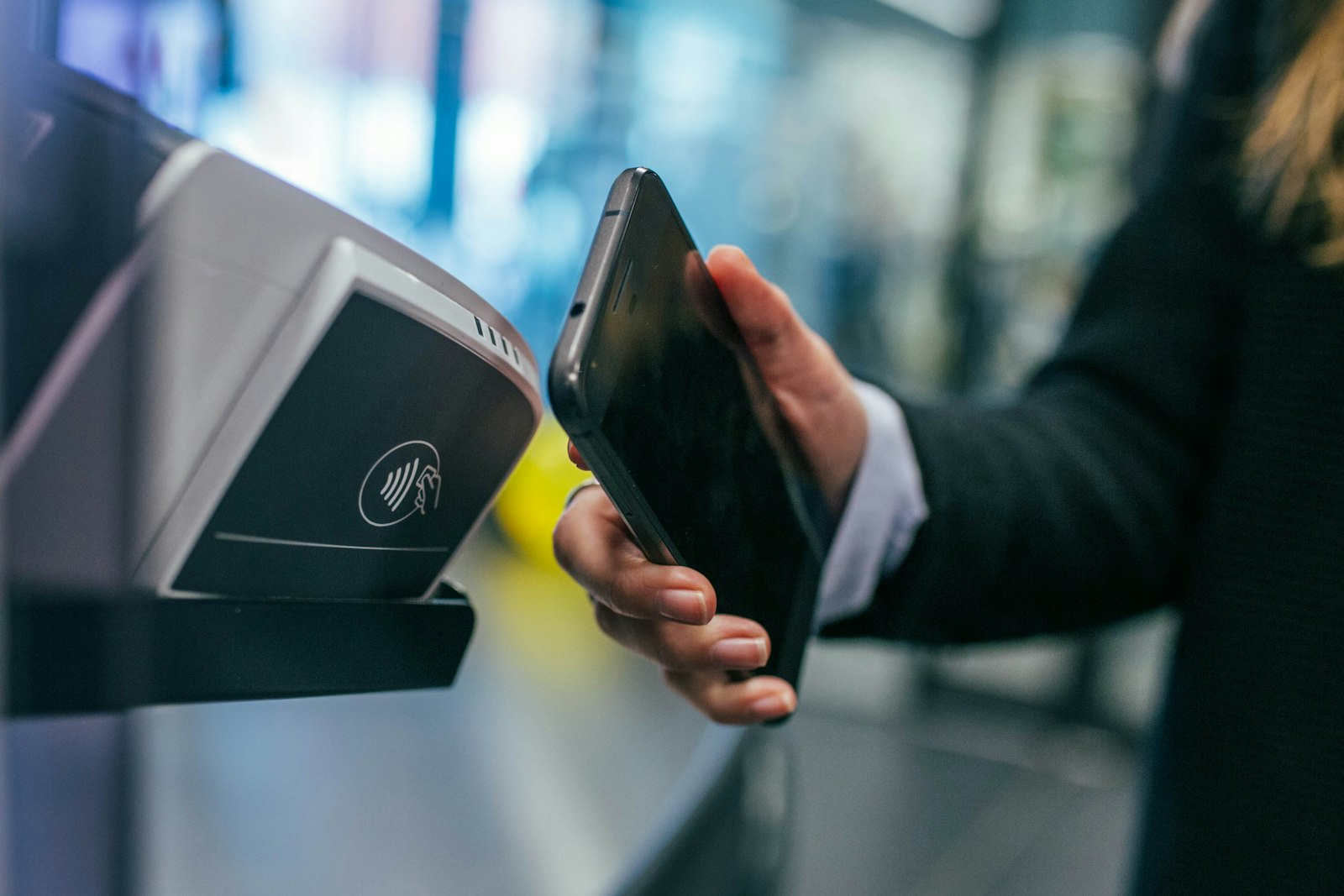 Customer tapping a smartphone at a payment counter